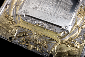 Close up detail of jewelry box cover featuring golden relief of scroll that is etched with the words "Idaho the Gem of the Mountains" 