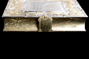 Close up detail of one long edge of object, featuring an etched scene of a miner with pack mules. Jewelry box clasp is closed, engraved with text that reads "DESIGNED BY THE WOMEN OF MOSCOW FOR THE COLUMBIAN EXPOSITION '93"