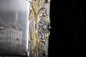 Close up detail of jewelry box cover featuring opal reportedly mined very near to Moscow, Idaho. Opal is set in golden flower design, golden relief of wheat shafts surround the stone. 