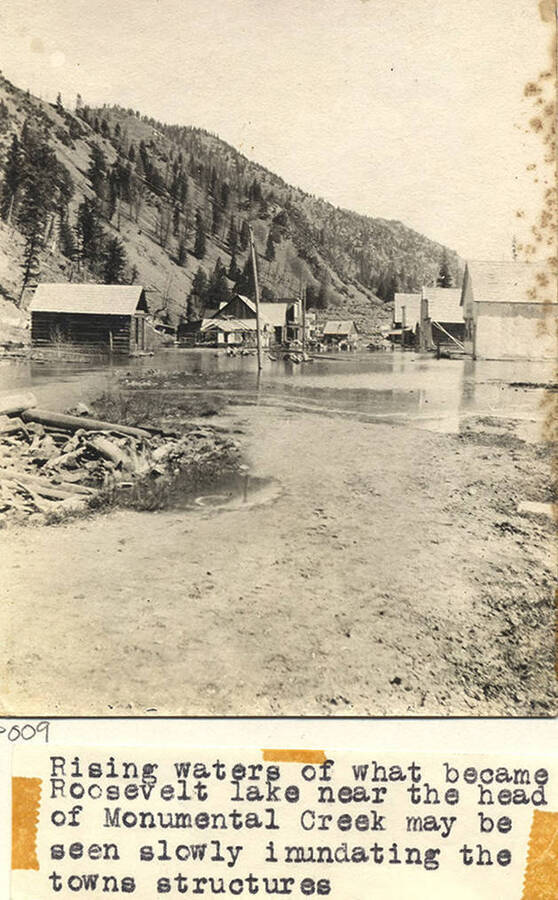 Photo caption reads: 'Rising waters of Monumental Creek may be seen slowly inundating towns structures.'