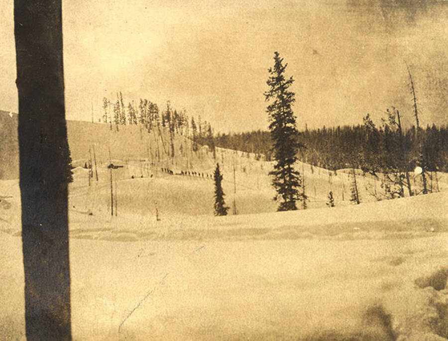 Funeral of Mr. C.A. Gordon in the snow. A dogsled team can be seen in the distance.