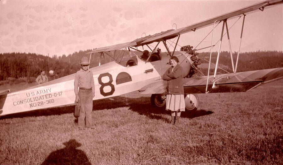 Adolph "Bill" (left) and mother, Golda Stonebraker, stand near a National Guard 116th Observation Squadron. The plane reads: 'U.S. Army Consolidated 0-17 NG 28-360' on its side. Plane is parked in the Chamberlain Basin meadow near the Stonebraker Ranch. The pilot was Nick Mamer.