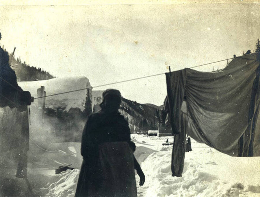 Lillian Stonebraker hangs clothing on a clothesline in the snow. Located in the village of Roosevelt, Idaho.