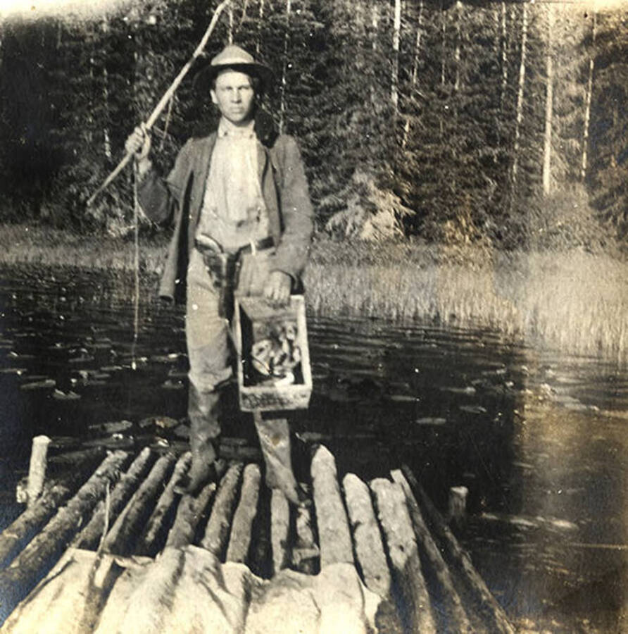 Sumner Stonebraker on a raft with a box of caught fish. The photo caption reads: 'A tired fisherman.'
