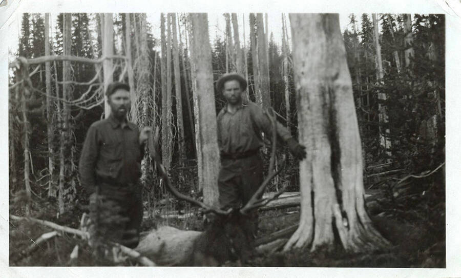 W. A. Stonebraker (right) and an unidentified man pose holding the antlers of a bull elk.