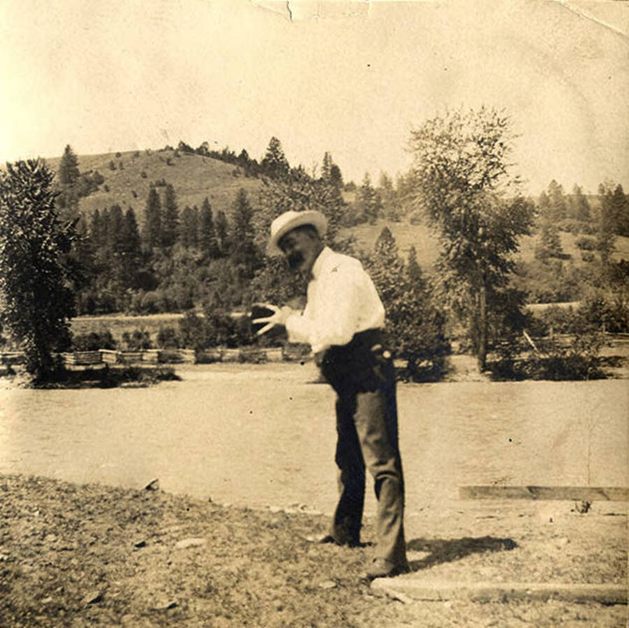 J. M. Woodward poses with a camera on a river bank of the South Fork of the Clearwater River in Stites, Idaho.