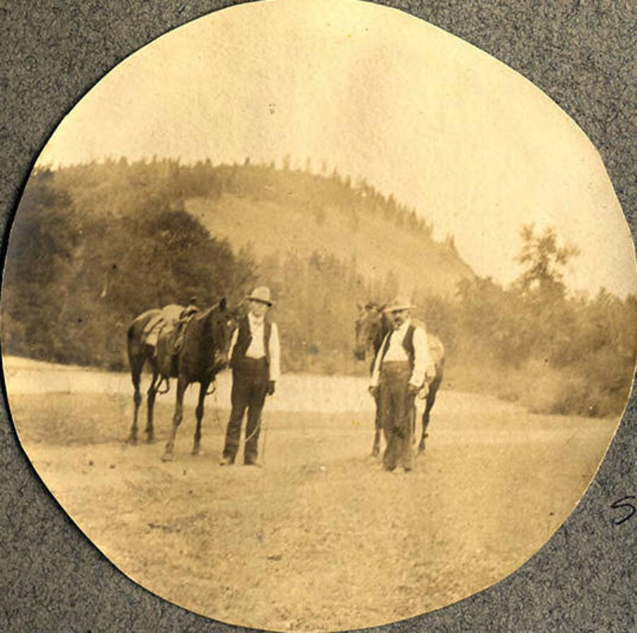 W. A. Stonebraker (left) and Dr. J. M. Woodburn (right) pose with horses near the Clearwater River.