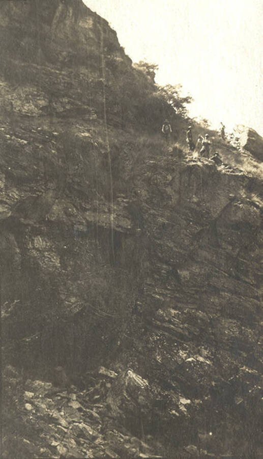Men on rocky cliff.