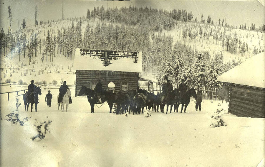 Horses and men wait near the Stonebraker Ranch in the snow.
