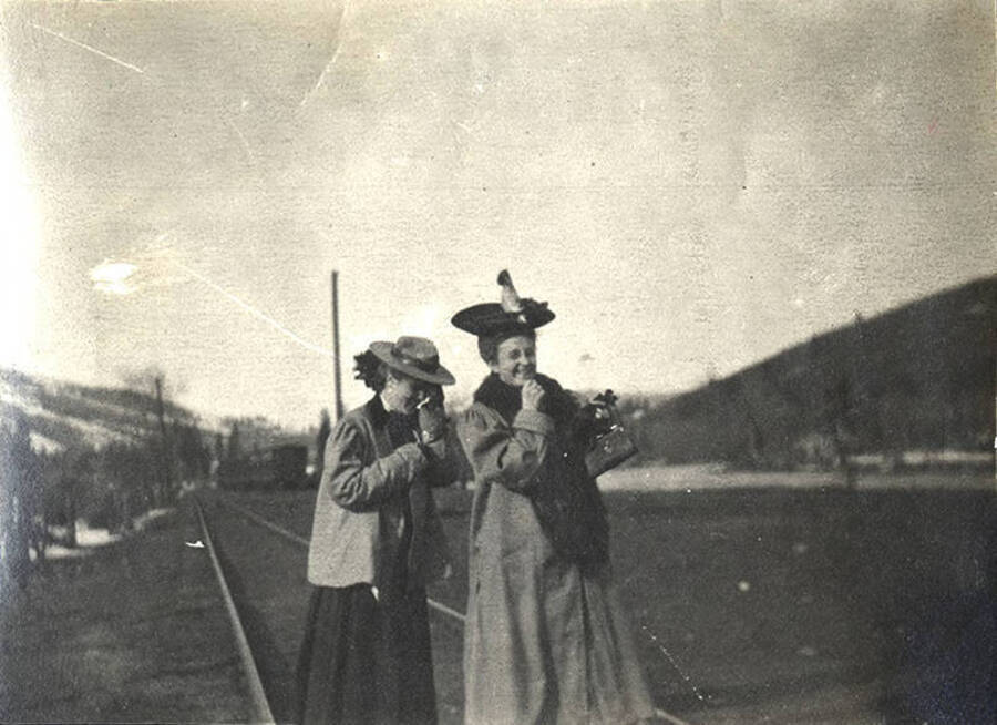 Two unidentified women laugh standing on the train tracks outside Stites, Idaho. 