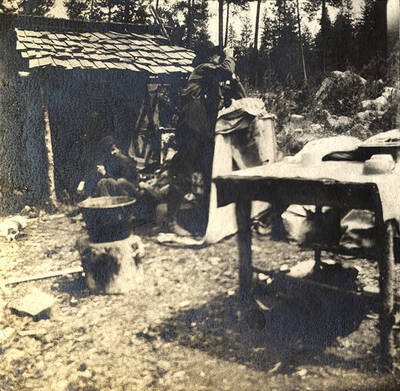 One man peers through binoculars away from camp.