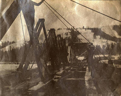 Snowy construction site for a bridge across the river.
