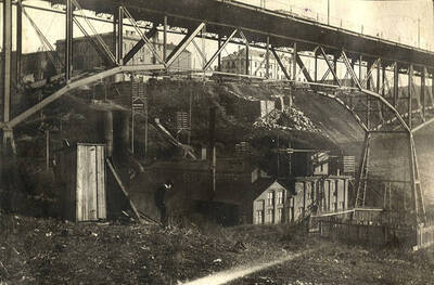 A man stands near the steel bridge with buildings in the background. Spokane Falls in Spokane, Washington.