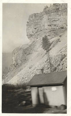 View taken from a moving train with rock formation in the background.