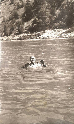 Man with a life jacket floats in the Clearwater River.