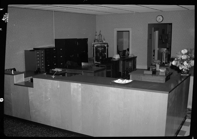 The front counter of Citizens Utility Company building is visible, with several desks in the area behind it.