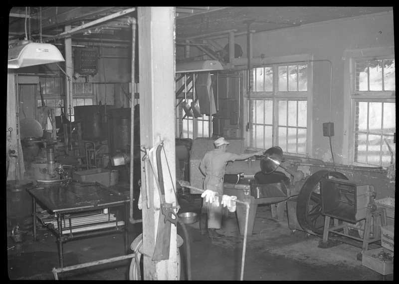 Photo of a man operating a piece of machinery inside the Wallace Meat Company building.