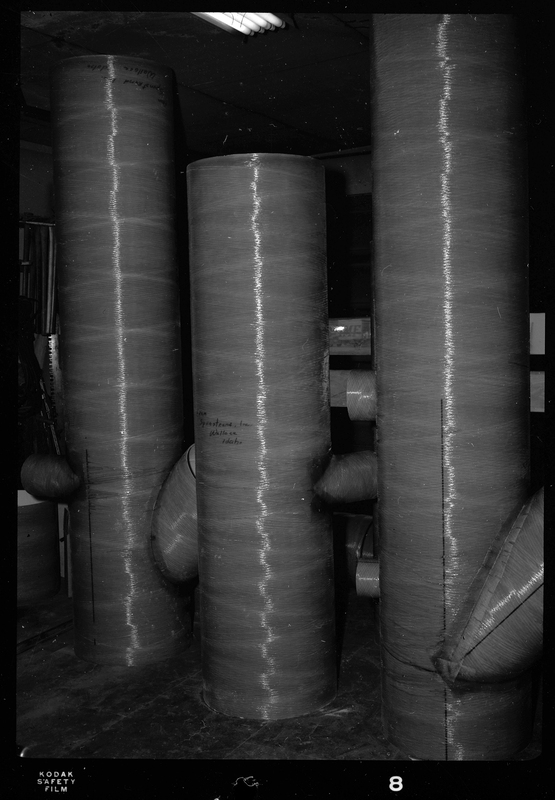 Photo of Spunstrand Incorporated equipment in a room, possibly HVAC system work. There are three tubes that come out of the floor and almost reach the ceiling.