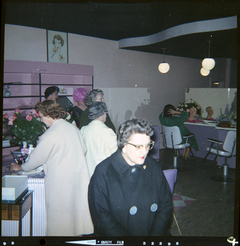 Photo of the interior of Beauty Marte during its store opening. Color photo of several women standing at the front counter of the store.