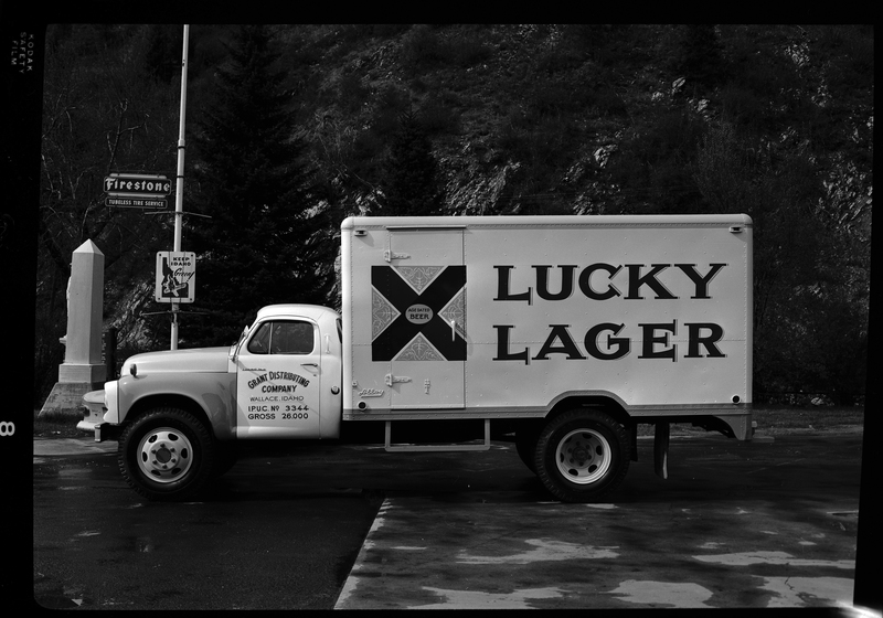 Photo of a Grant Distributing Company truck with a "Lucky Lager" beer decal on the side of it. It is parked on the side of the road for pictures.