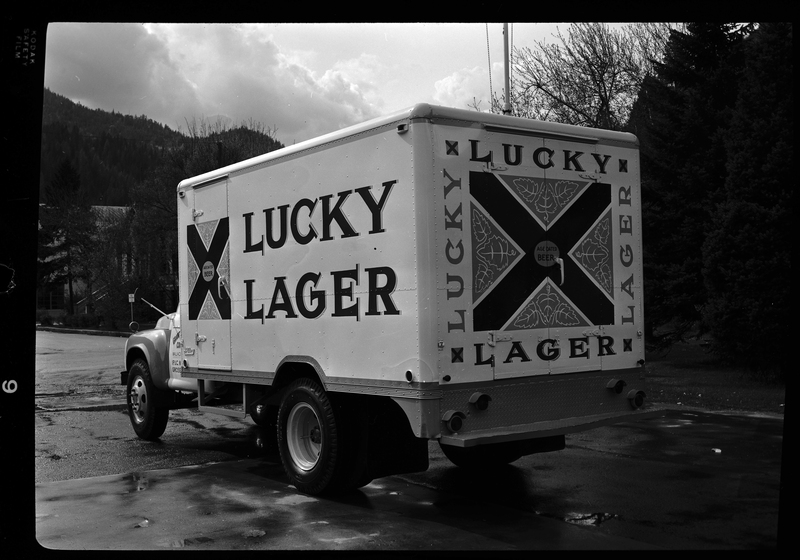 Photo of a Grant Distributing Company truck with a "Lucky Lager" beer decal on the side and back of it. It is parked on the side of the road for pictures.