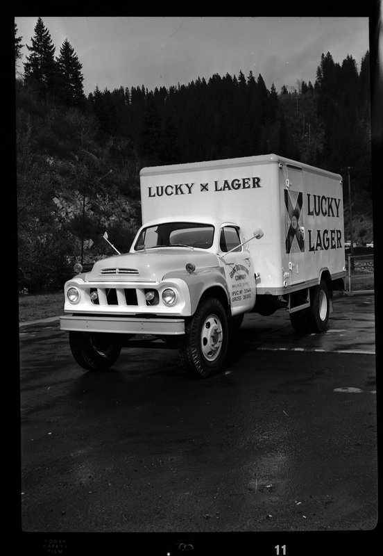 Photo of a Grant Distributing Company truck with a "Lucky Lager" beer decal on the front and side of it. It is parked on the side of the road for pictures.