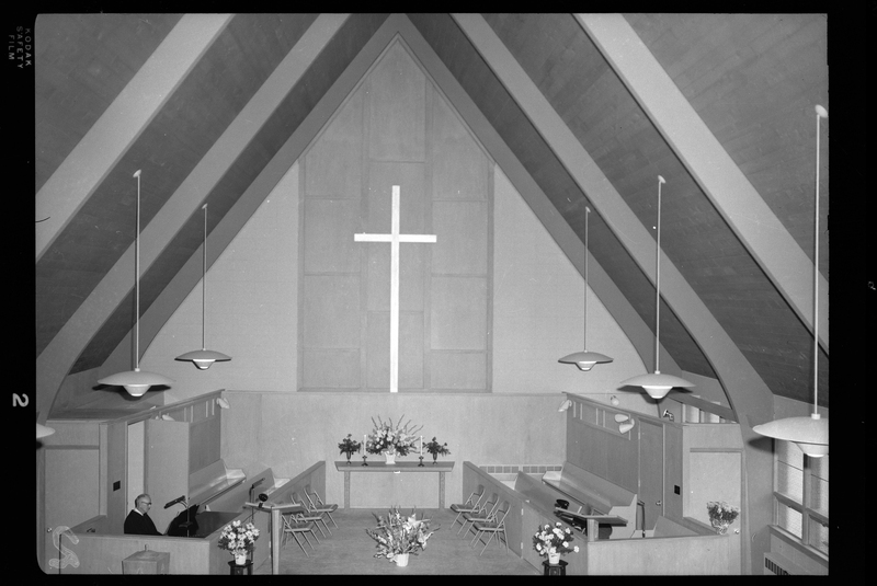 Photo of the stage of the Congregational Church. There is only one person there, behind a piano.