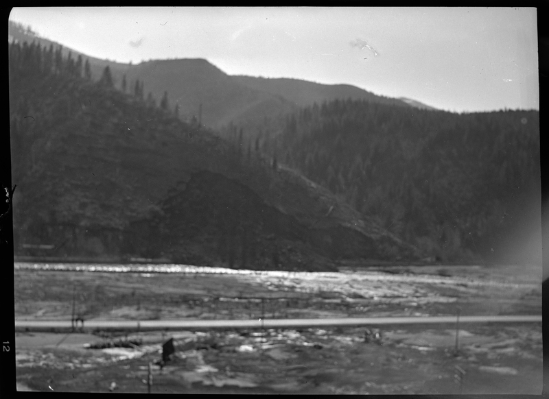 Photo of an unidentified outdoor scene. The area is muddy and empty, and there is a river in the background. The photo is extremely blurry.