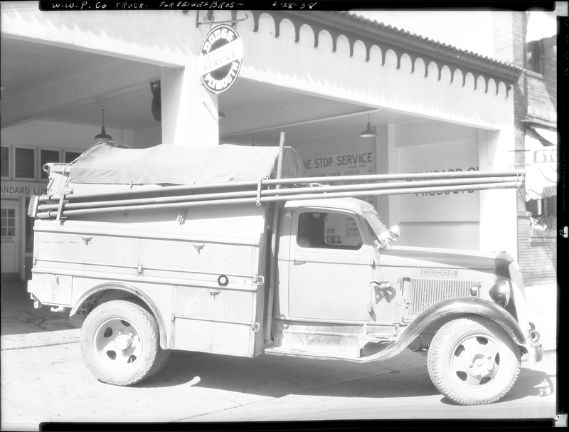 Photo of the W. W. P. Company Truck that is described as "For Reiger Bros." The truck is partially parked under an overhang of a building.
