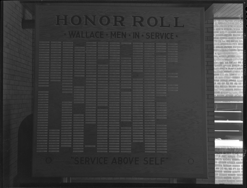 Photo of the Wallace High School Service Honor Roll. There is a list of names on the board and some blank spaces. Under the list of names it reads, "Service above self."