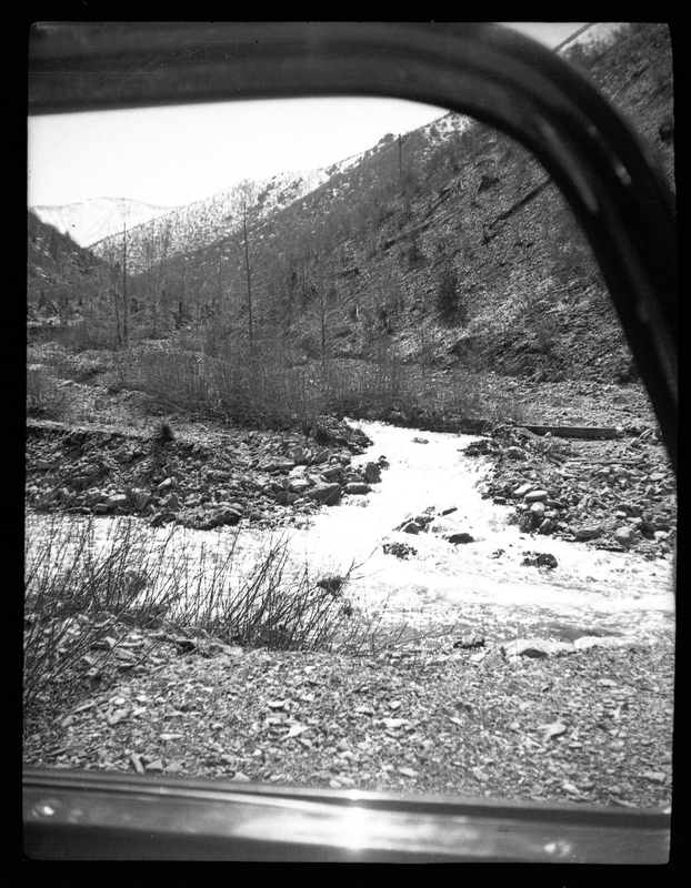 Photo of an unidentified outdoor scene. The area is rocky and appears to have a river running through it.