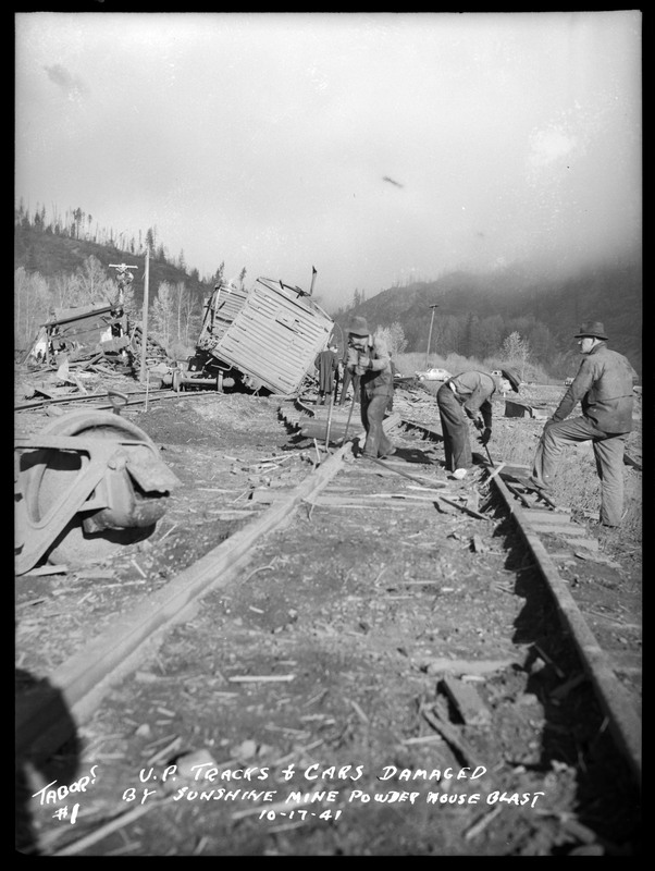 People inspecting Union Pacific Railroad cars and tracks which were damaged by the Sunshine Mine powderhouse explosion.