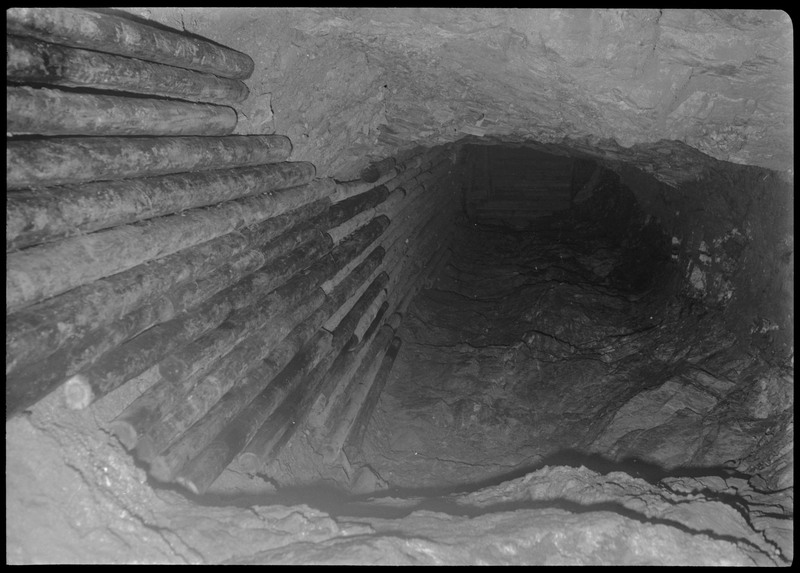 The tunnel in Lucky Friday mine. The floor is uneven and there appears to be support beams on the wall.