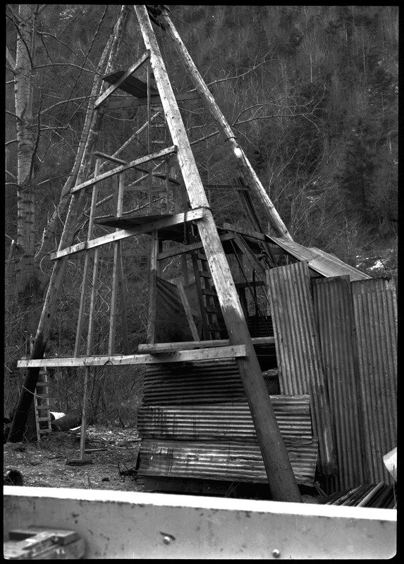 An unidentified structure that was previously described as "Sunshine Mine cons." The structure is made of metal and sheets of what is likely aluminum leaned against it.