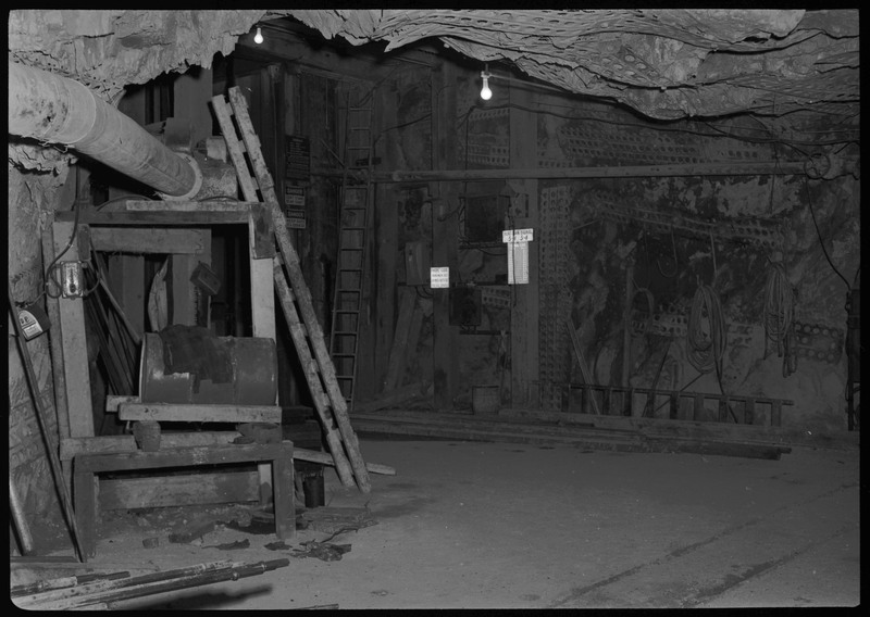 The Lucky Friday Mine main shaft with it's elevator. There are several signs throughout the mine shaft that read, "DANGER DON'T STAND NEAR SHAFT," "KEEP GATE CLOSED," "PHONE CODE 1 RING MAIN HST. 3 RINGS OUTSIDE STA. SIG. LEVELS," and "HURT MAN SIGNAL 5-4 5-4."