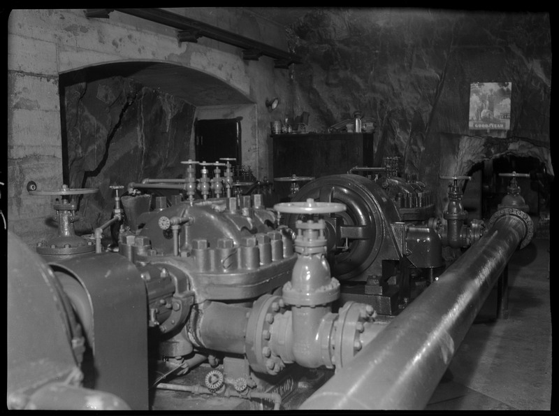 An unidentified piece of equipment/machinery in the underground facilities at Hecla Mine. There is a Good Year poster on one of the walls.