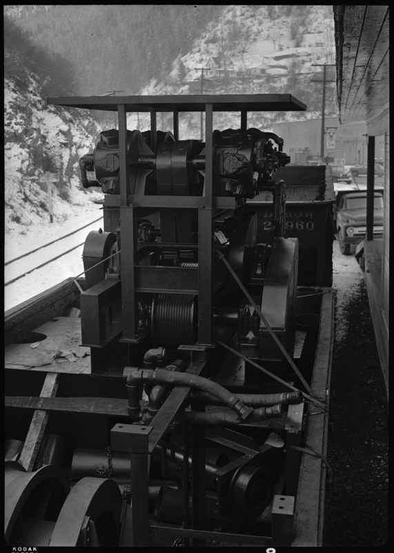 Mining equipment used by Coeur d'Alene Mining Company. The machine appears to be attached to a train car, seeing as how snow covered train tracks are nearby.