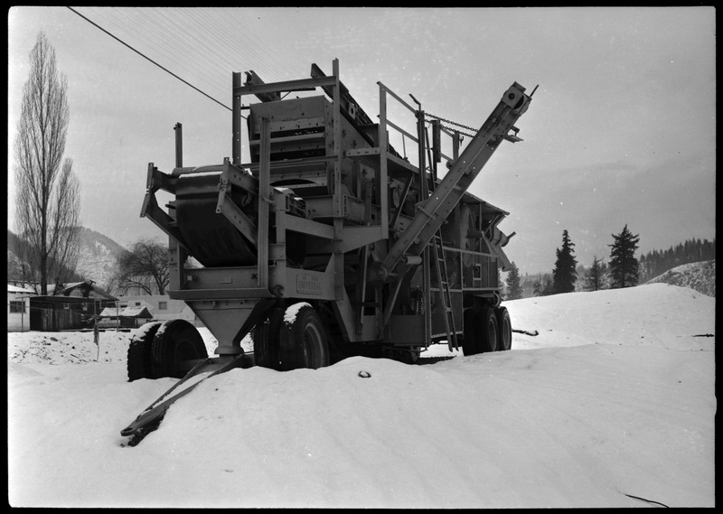 A truck used by Coeur d'Alene Mining Company. The truck appears to also serve as mining machinery, and it is parked outside in the snow.