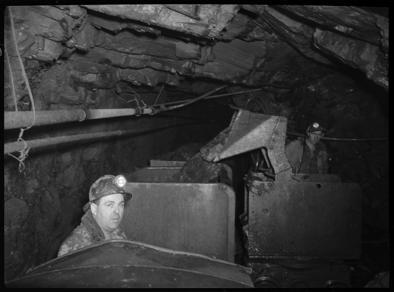 Two miners working inside the mine carts at Day Mine.