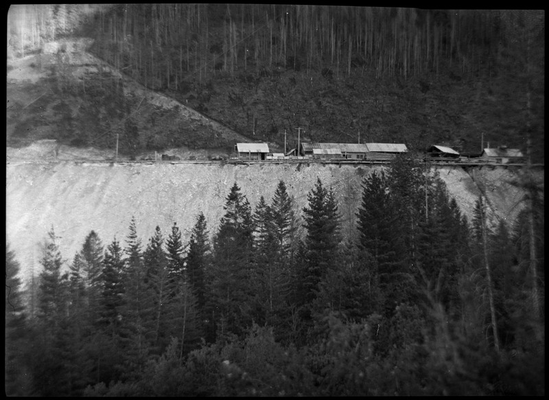Image of the Silver Summit mine complex from a distance. There are trees between the photographer and the mine.