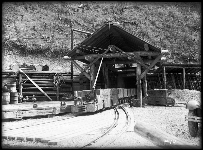 Image of the Silver Summit mine entrance. There are mine carts on tracks that leads into the mine.