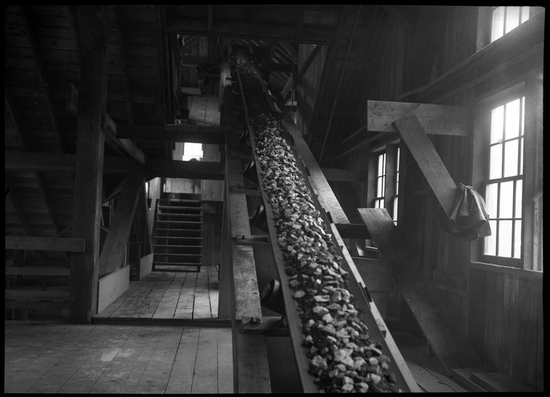 Ore being moved down a conveyor belt, moving down several floors of a building.