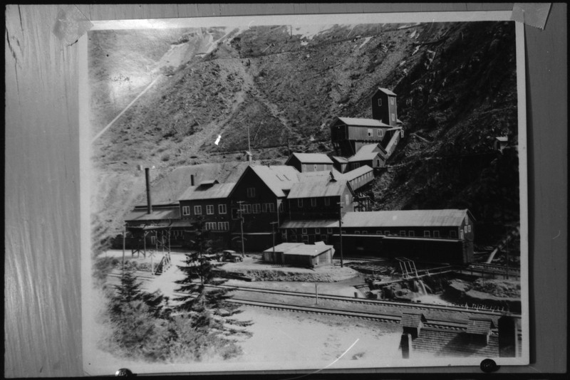 Image of a photograph overlooking Tamarack Mill in New Meadows, Idaho. There are railroad tracks running in front of the mill.