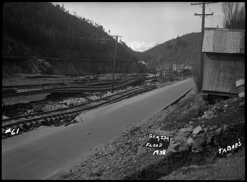 Image of the damage caused by the Gem, Idaho flood. The railroad tracks and the road near the river were damaged.