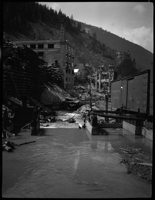 Image of the Gem, Idaho flood. There is water overflowing the street and down a set of stairs near several buildings.