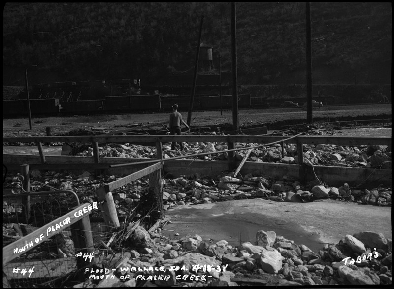 Image of the Wallace, Idaho flood at the mouth of Placer Creek. There is a man standing among the wreckage.