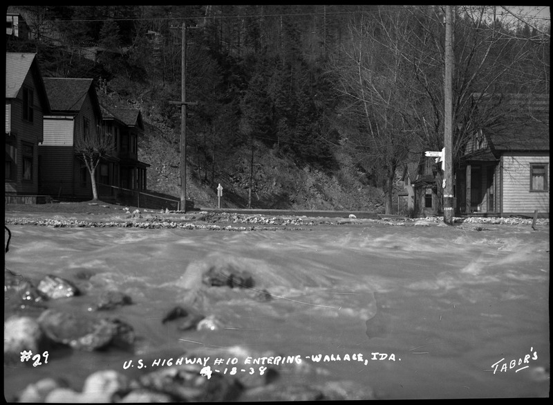The Wallace, Idaho flood on U.S. Highway #10 entering Wallace. The water is rushing past some houses.