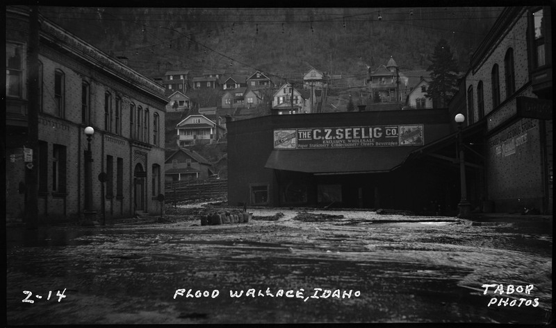 Image of a flood in Wallace, Idaho. The water is covering the streets and up against buildings, including "The C.Z. Seelig Co." building.