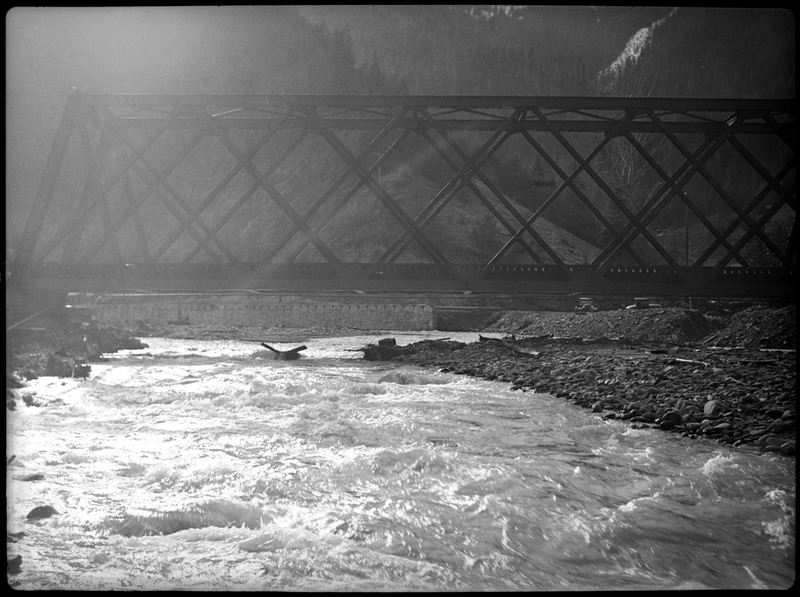 Bridge during a flood in Wallace, Idaho. The bridge appears to be still standing, with water rushing beneath it.