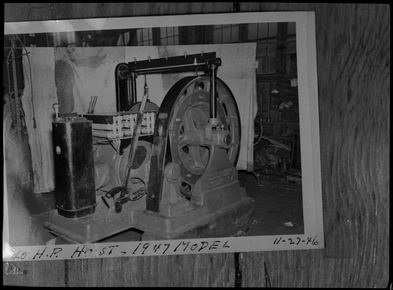 An image of a photograph depicting a mine hoist inside a building. The caption on the photograph reads "40 H.P. hoist - 1947 model."